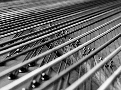 Cordes de basses filées en cuivre d'un piano à queue.